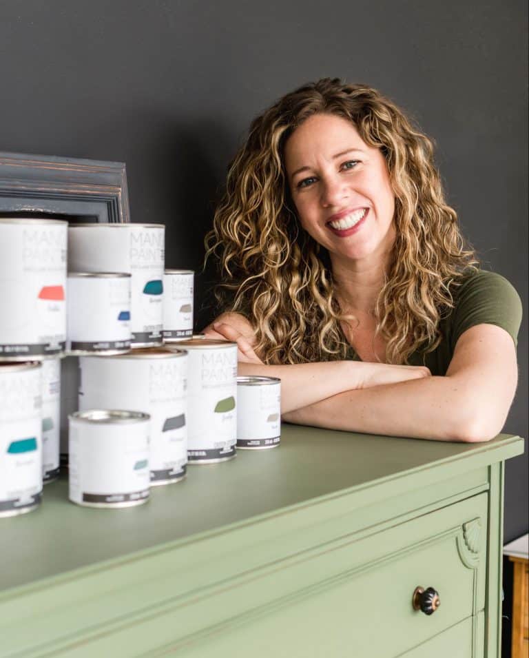 Melanie Curley CEO of Mango Paint invites you to fill out a retailer application while leaning on a painted dresser
